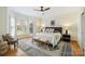 This spacious main bedroom offers a ceiling fan, rug, bench, and many windows for lots of natural light at 8000 Greencastle Dr, Charlotte, NC 28210