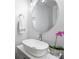 This modern powder room features a vessel sink, large round mirror and orchid at 8000 Greencastle Dr, Charlotte, NC 28210