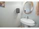 Half bathroom featuring pedestal sink, round mirror, and light-blue painted walls at 8143 Summit Ridge Dr # 41, Catawba, NC 28609