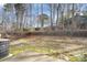 Expansive backyard featuring a stone retaining wall, mature trees and a concrete patio at 8460 Summerglen Cir, Charlotte, NC 28227