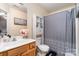 Bathroom features a sink, toilet, bathtub with shower, and decorative storage cabinet at 8460 Summerglen Cir, Charlotte, NC 28227