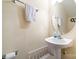 Simple bathroom with a pedestal sink, round mirror and convenient towel bars at 8460 Summerglen Cir, Charlotte, NC 28227