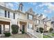 Charming two-story townhome with brick facade, black shutters, landscaped yard, and covered front porch at 8460 Summerglen Cir, Charlotte, NC 28227