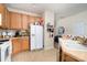 Functional kitchen with wooden cabinets, white appliances, and a tile floor at 8460 Summerglen Cir, Charlotte, NC 28227