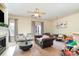 Inviting living room featuring a fireplace, ceiling fan, a view of the dining room and a comfortable leather sofa at 8460 Summerglen Cir, Charlotte, NC 28227