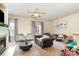 Inviting living room featuring a fireplace, ceiling fan, a view of the dining room and a comfortable leather sofa at 8460 Summerglen Cir, Charlotte, NC 28227