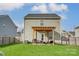 Wide shot of the backyard, showcasing a covered patio with furniture, well-maintained lawn, and privacy fence at 921 Von Buren Blvd, Rock Hill, SC 29730