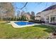 Gorgeous backyard pool on a sunny day, surrounded by a lush lawn and manicured landscaping at 10101 Bayart Way, Huntersville, NC 28078