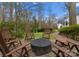 A backyard fire pit with 6 Adirondack chairs on stone platform with grass background at 105 Hillside Dr, Davidson, NC 28036
