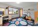 Cozy bedroom featuring a colorful floral rug, large window, and comfortable workspace at 105 Hillside Dr, Davidson, NC 28036