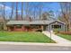 Charming brick and siding home with well-manicured lawn, mature trees, and a stone walkway at 105 Hillside Dr, Davidson, NC 28036