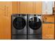 Modern laundry room with wood cabinets and newer washer and dryer units at 105 Hillside Dr, Davidson, NC 28036