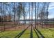 Picturesque backyard offers serene lake views framed by mature trees and a secure fence at 111 Kent Ct, Mooresville, NC 28117
