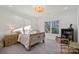 Bright bedroom featuring a floral bedspread, decorative nightstands, and a golden chandelier at 111 Kent Ct, Mooresville, NC 28117