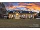 Charming single-story home featuring a manicured lawn, decorative shutters and dormer windows at sunset at 111 Kent Ct, Mooresville, NC 28117
