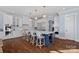 Open-concept kitchen with a large island, modern appliances, white cabinetry, and stylish bar stools at 111 Kent Ct, Mooresville, NC 28117