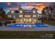 Stunning backyard features a sparkling pool, outdoor dining area, and lush landscaping, perfect for entertaining at 111 Kent Ct, Mooresville, NC 28117