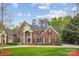 Stately brick home with lush lawn, mature trees, and circular driveway creates exceptional curb appeal at 12011 Olden Ct, Charlotte, NC 28262