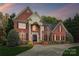 Beautiful exterior featuring a brick facade, manicured landscaping, and a well-lit entrance, perfect for evening arrivals at 12011 Olden Ct, Charlotte, NC 28262
