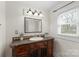 Bathroom featuring a wooden vanity with marble countertop and decorative mirror at 1301 Martin Luther King Ave, Kannapolis, NC 28083