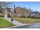 Brick home on a sloped lawn, featuring an attached garage and mature trees at 131 Sardis Pointe Rd, Matthews, NC 28105