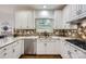 Bright kitchen showcasing white cabinetry, stainless steel appliances, tile backsplash, and undermount sink at 131 Sardis Pointe Rd, Matthews, NC 28105