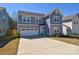 Charming two-story home with stone accents, a two-car garage and a spacious concrete driveway at 133 Batten Ridge Dr, Statesville, NC 28677