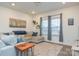Bright living room features a large window, hardwood floors, a comfortable sectional sofa, and elegant decor at 133 Batten Ridge Dr, Statesville, NC 28677