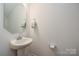 Elegant powder room featuring a pedestal sink, an octagonal mirror and neutral wall paint at 133 Batten Ridge Dr, Statesville, NC 28677