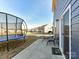 Back patio view featuring trampoline, patio set and lawn area in a residential neighborhood at 1444 Harleston St, Indian Trail, NC 28079