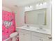 Bright bathroom with double sinks, vanity, large mirror, and a fun unicorn shower curtain at 1444 Harleston St, Indian Trail, NC 28079
