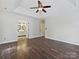 Main bedroom with ceiling fan, hardwood floors, and access to a bathroom with double vanity sinks at 14621 Sapphire Ln, Pineville, NC 28134