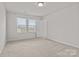 A bedroom featuring neutral walls and carpet, and a large window with blinds at 2032 Country Pl, Hickory, NC 28601