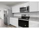 Close-up of the kitchen with white cabinets, stainless steel appliances, and granite countertops at 2032 Country Pl, Hickory, NC 28601