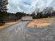 Exterior of a cozy single-story home with neutral siding, set against a backdrop of mature trees and an overcast sky at 238 Fairchase Cir # 54, Stony Point, NC 28678