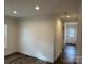 Bright living room featuring modern flooring and neutral walls, leading to an adjacent hallway and entryway at 238 Fairchase Cir # 54, Stony Point, NC 28678