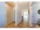 Bright hallway with hardwood floors leads to various rooms, showcasing the home's layout and natural light at 2513 Crimson Way, Monroe, NC 28112