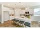 Bright kitchen features white cabinets, stainless appliances, island with seating, and pendant lighting at 2513 Crimson Way, Monroe, NC 28112
