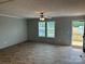Open-concept living room featuring two bright windows, wood-look floors, and a ceiling fan for comfortable living at 252 Fairchase Cir # 56, Stony Point, NC 28678