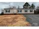 Tan home with black shutters, a small porch, and a freshly graveled driveway at 252 Fairchase Cir # 56, Stony Point, NC 28678