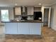 An open kitchen with a large island, grey cabinets, modern appliances, and hardwood flooring at 252 Fairchase Cir # 56, Stony Point, NC 28678