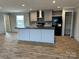 Modern kitchen features an island with a sink, gray cabinetry, and black appliances at 252 Fairchase Cir # 56, Stony Point, NC 28678