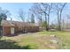 Large backyard with brick house, patio, and table set, surrounded by a chain link fence at 2537 Wood Star Ct, Matthews, NC 28215