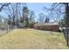 Backyard view with brick house, shed, chain link fence, and mature trees at 2537 Wood Star Ct, Matthews, NC 28105