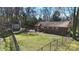 View of the backyard with a brick house, storage shed and chain link fence at 2537 Wood Star Ct, Matthews, NC 28105
