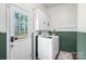 Laundry room with updated machines, white cabinets, and a door leading to the yard at 2537 Wood Star Ct, Matthews, NC 28105