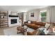 Bright living room with a brick fireplace, large leather couch, and wood floors at 2537 Wood Star Ct, Matthews, NC 28105