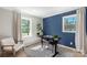 Home office space with bright blue accent wall and large window providing plenty of natural light at 2537 Wood Star Ct, Matthews, NC 28105