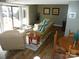 Bright living room with lake views, wicker furniture, wood floors, and glass coffee table at 254 N Shoreline N Dr # 38, New London, NC 28127