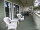 Comfortable covered porch with white wicker furniture, perfect for relaxation and enjoying outdoor views at 254 N Shoreline N Dr # 38, New London, NC 28127